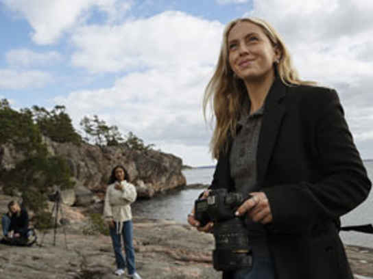 Bilde av en fotograf som tar bilder på en strand for å illustrere fakturakjøp fra Svea Bank.