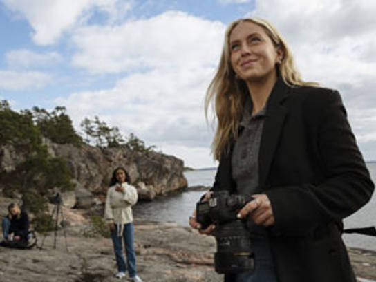Bilde av en fotograf som tar bilder på en strand for å illustrere fakturakjøp fra Svea Bank.