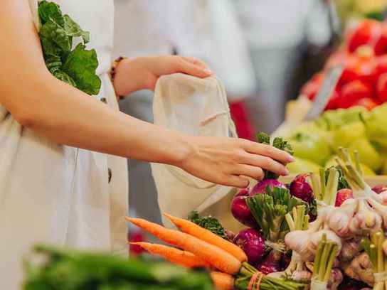 Kvinna köper grönsaker i matbutik
