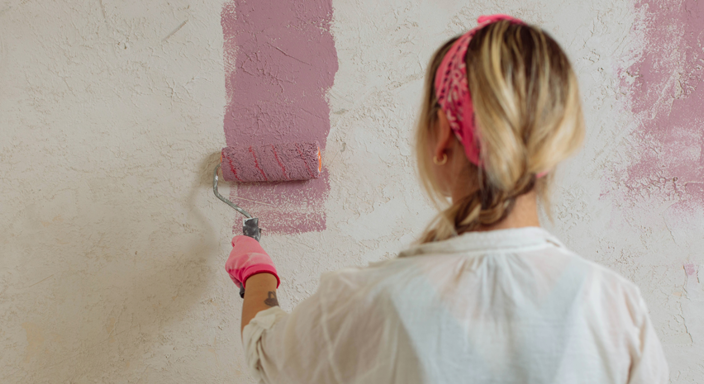Kvinna målar en vägg