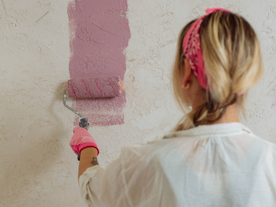 Kvinna målar en vägg