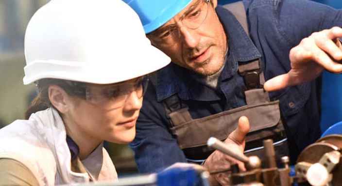 Kvinna och man med skyddshjälmar