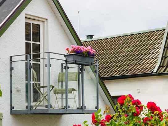 Balkong med blommor på vit villa