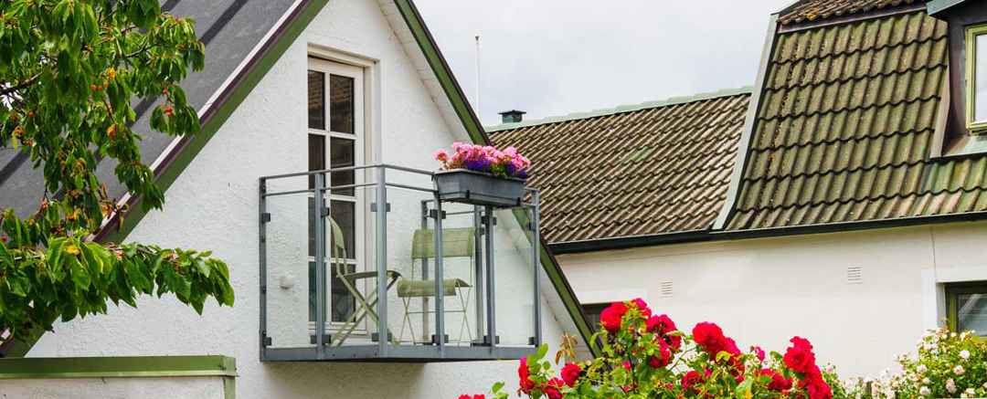 Balkong med blommor på vit villa