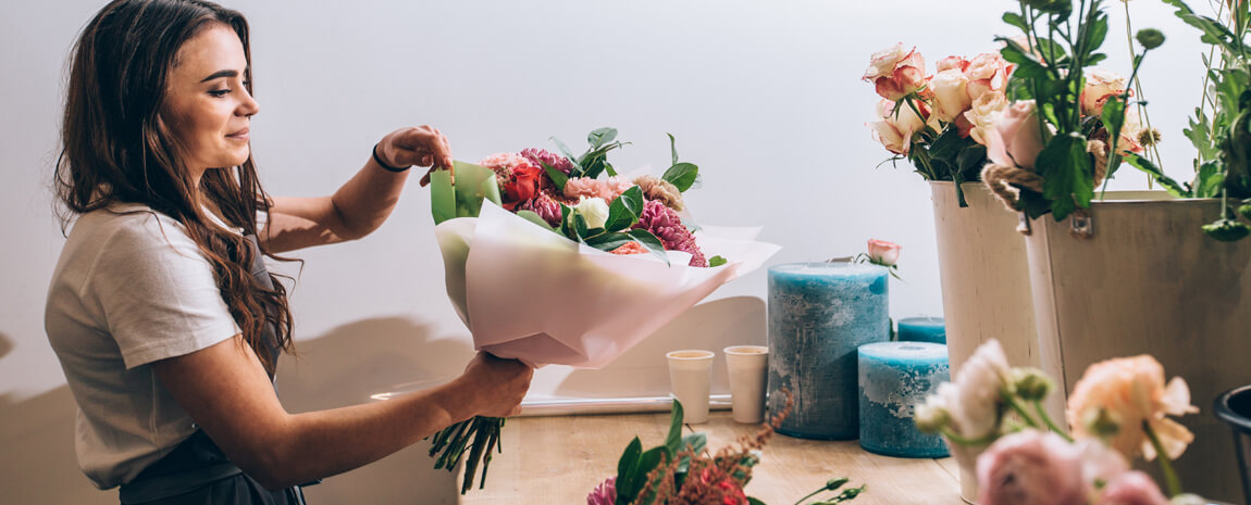 Kvinna binder bukett i blomsterbutik