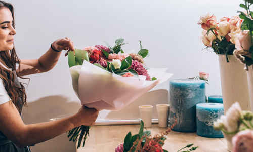 Kvinna binder bukett i blomsterbutik