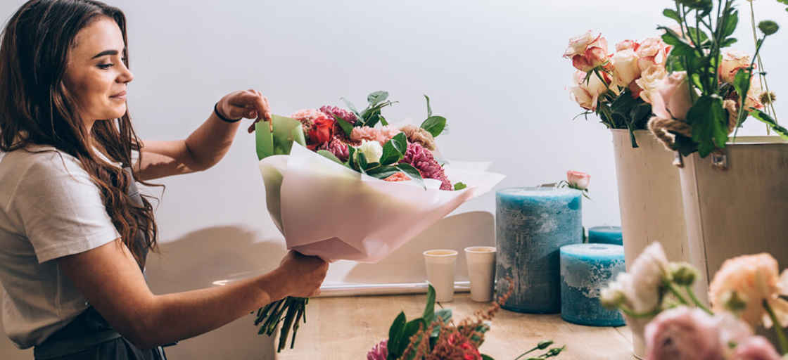 Kvinna binder bukett i blomsterbutik