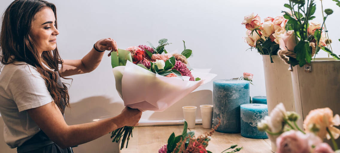 Kvinna binder bukett i blomsterbutik