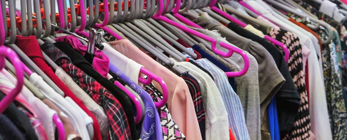 Kläder på klädhängare i sceondhand-butik