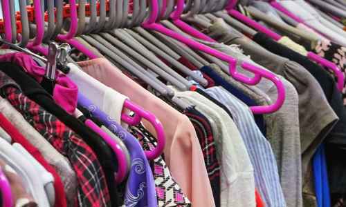 Kläder på klädhängare i sceondhand-butik