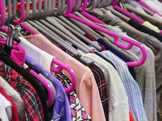 Kläder på klädhängare i sceondhand-butik