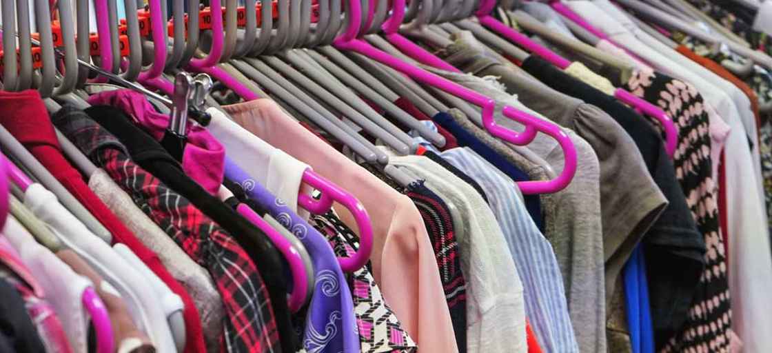 Kläder på klädhängare i sceondhand-butik