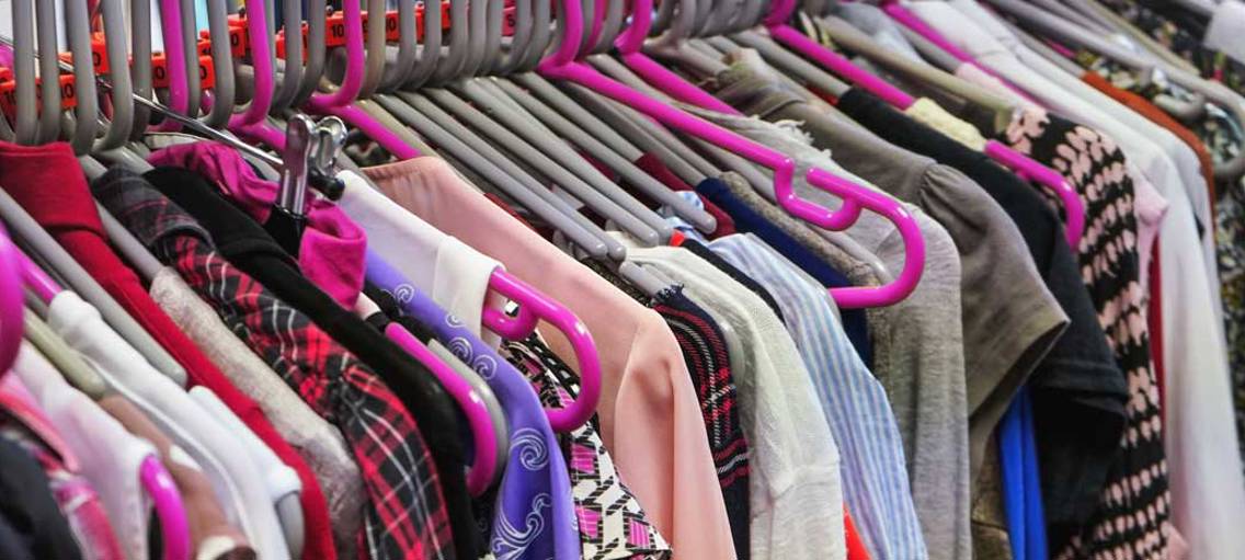 Kläder på klädhängare i sceondhand-butik