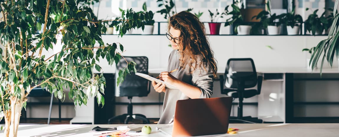 Kvinna på kontor med många växter