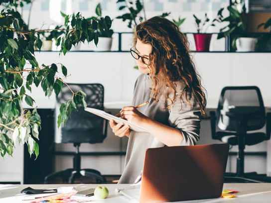 Kvinna på kontor med många växter