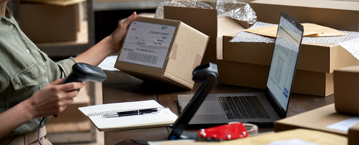 Person på lager scannar adresslapp på paket