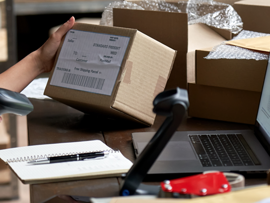 Person på lager scannar adresslapp på paket