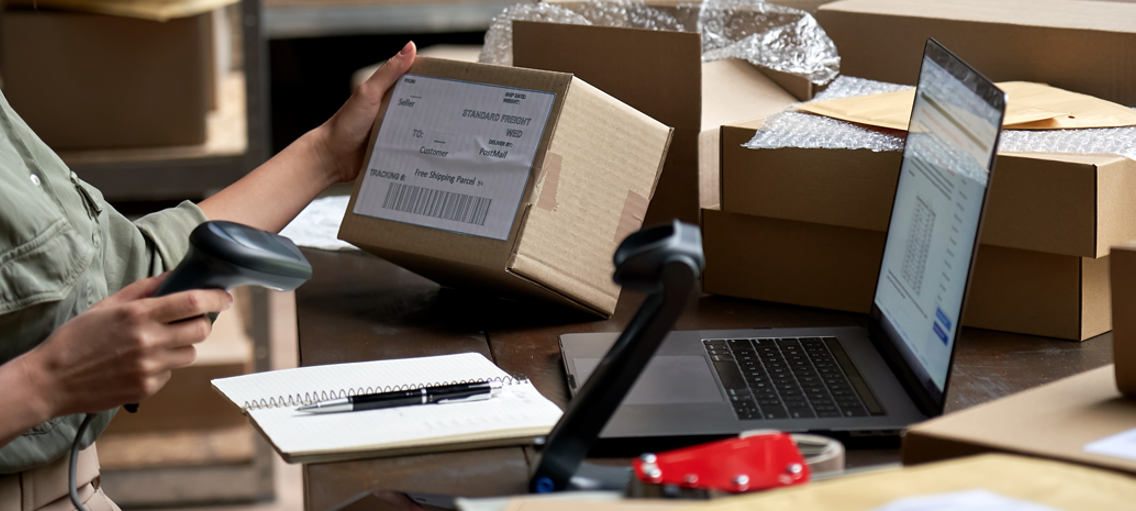 Person på lager scannar adresslapp på paket