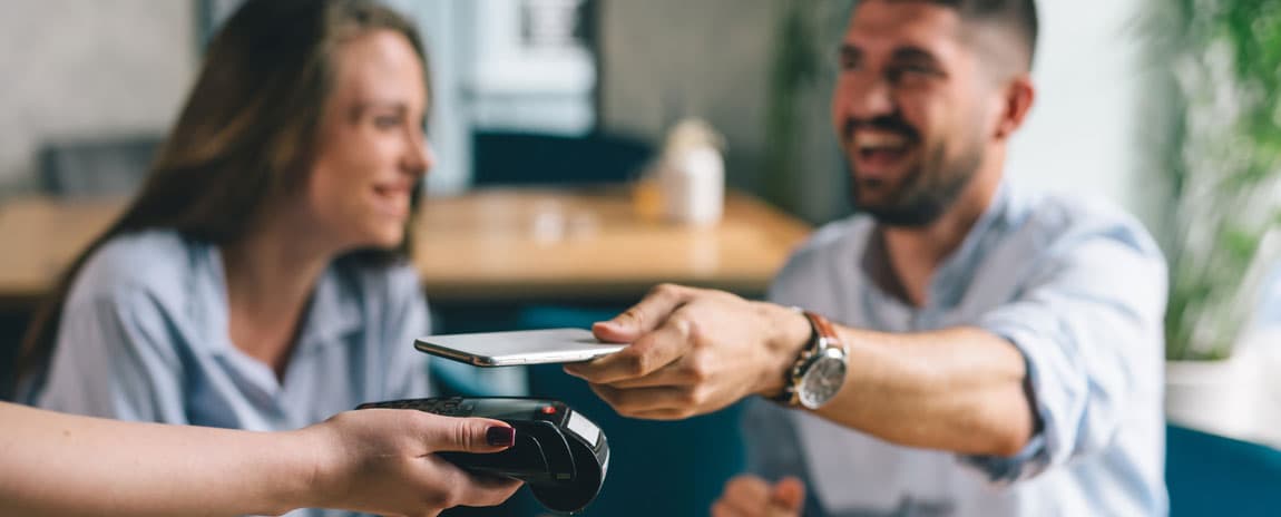 Ungt par betalar restaurangmiddag