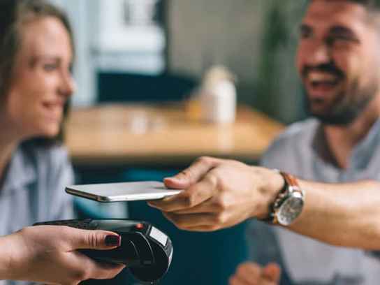 Ungt par betalar restaurangmiddag