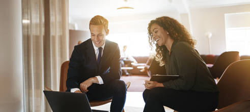Man en vrouw bespreken factoring achter laptop in Nederland