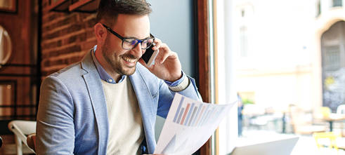 Ondernemer met papier met bedrijfsresultaten belt voor facturen verkopen