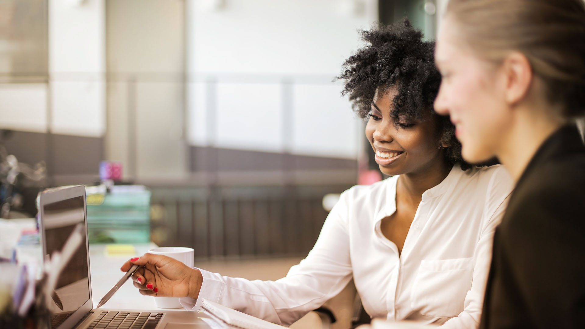 Vrouwen bespreken soorten factoring achter laptop