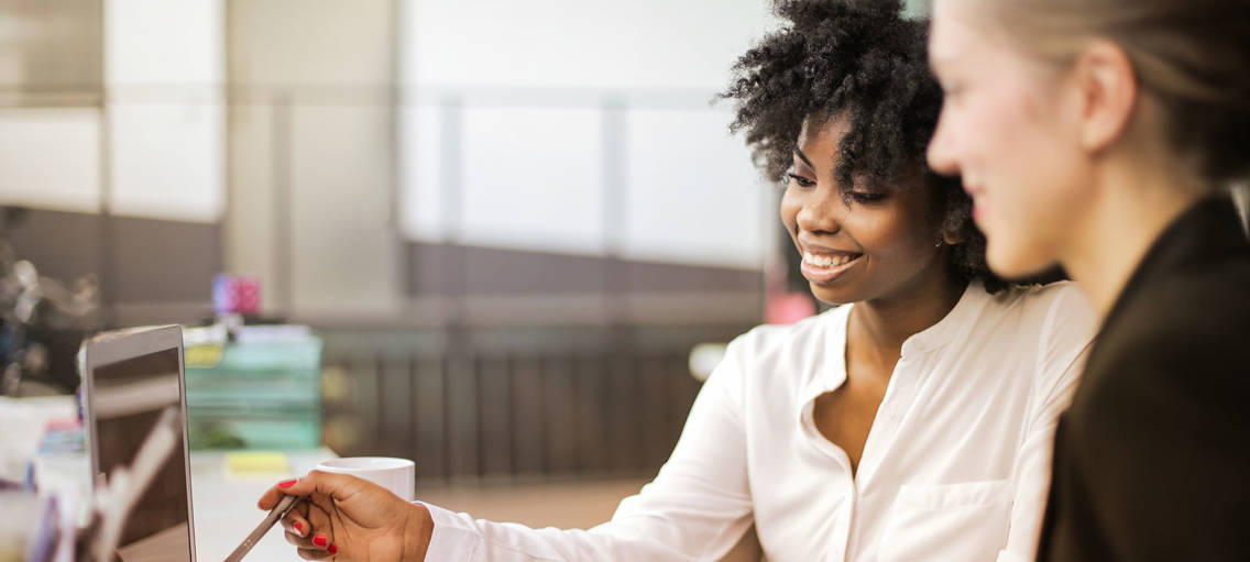 Vrouwen bespreken soorten factoring achter laptop