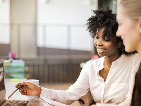 Vrouwen bespreken soorten factoring achter laptop