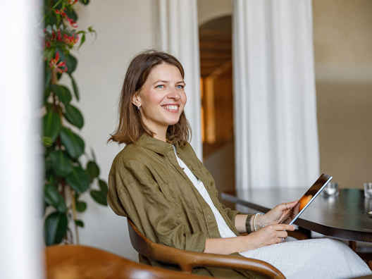 Vrouwelijke ondernemer wil facturen verkopen met tablet op stoel