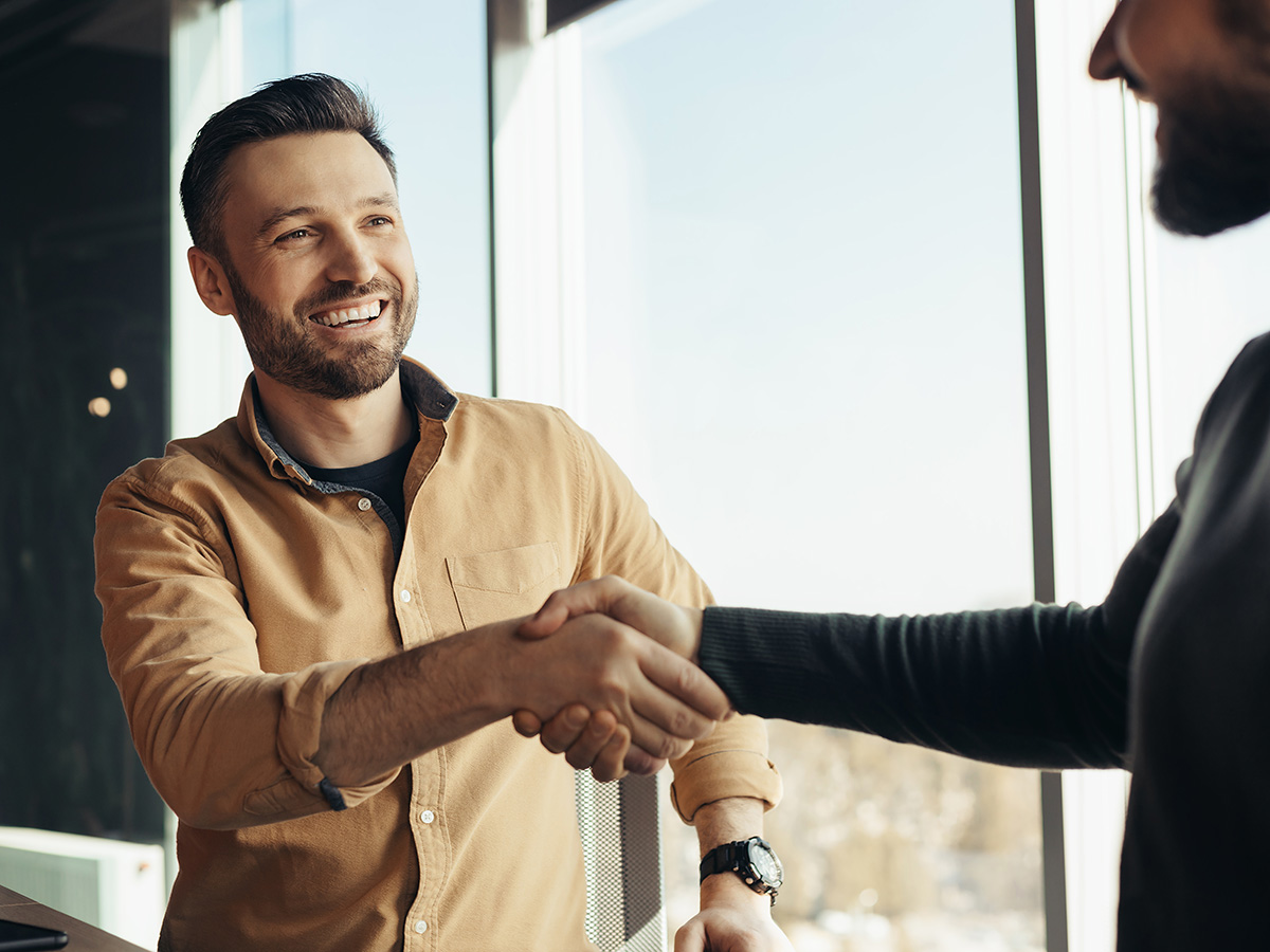 Mannen schudden elkaar de hand op kantoor om factuur direct betaald te krijgen
