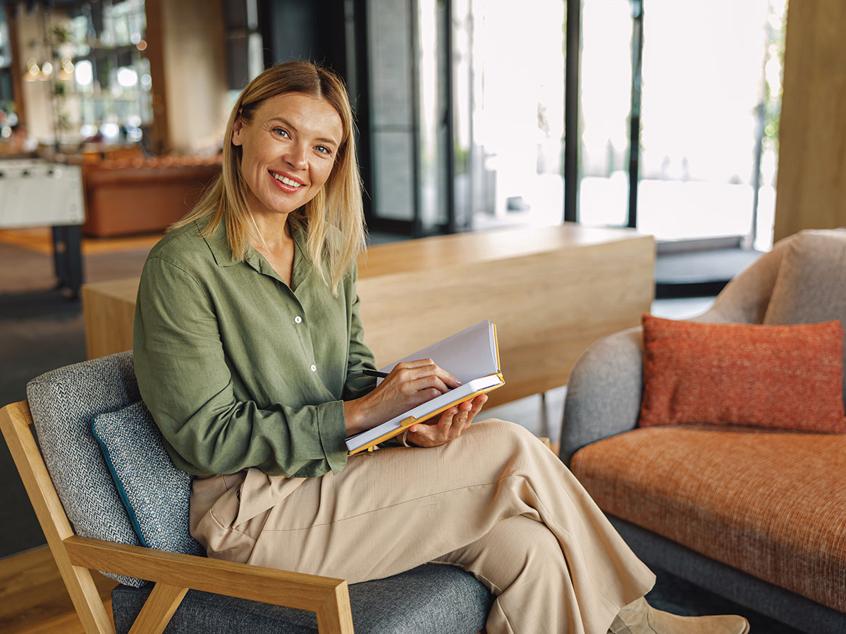 Vrouw schrijft in notitieblok hoe factuur financiering werkt