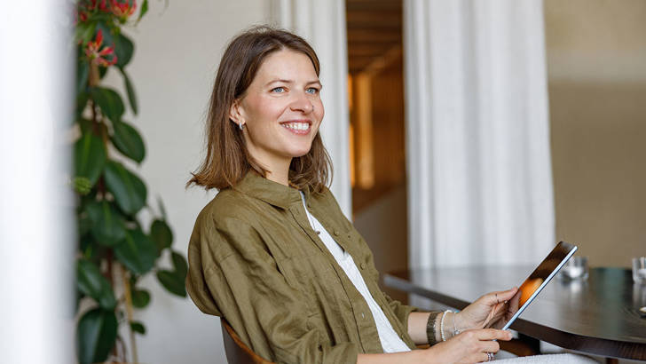 Vrouwelijke ondernemer wil facturen verkopen met tablet op stoel