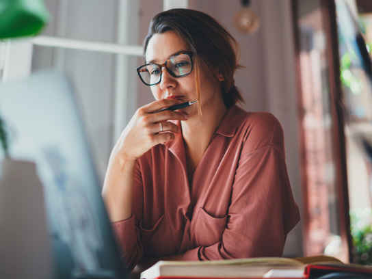 Kvinna tittar fundersamt på en laptop