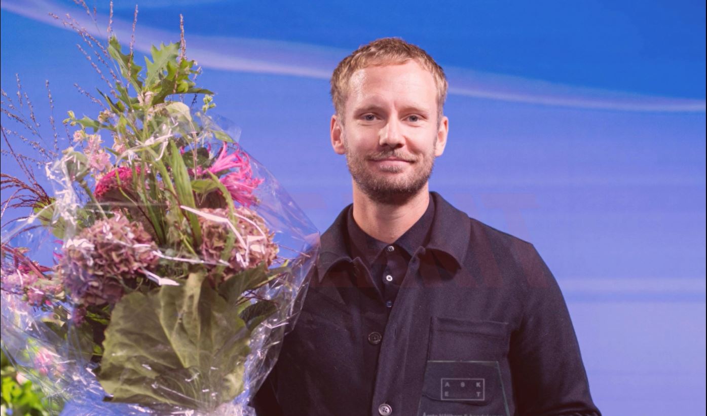 Man på scen med blombukett