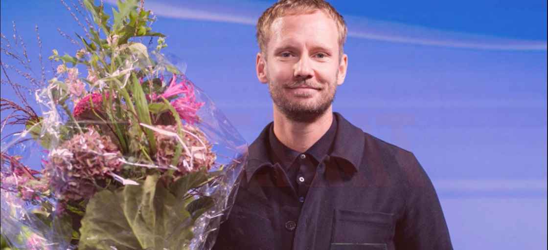 Man på scen med blombukett