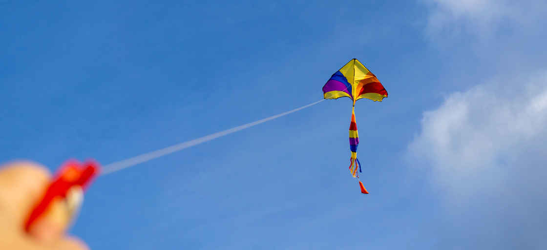 Gul och röd drake mot blå himmel