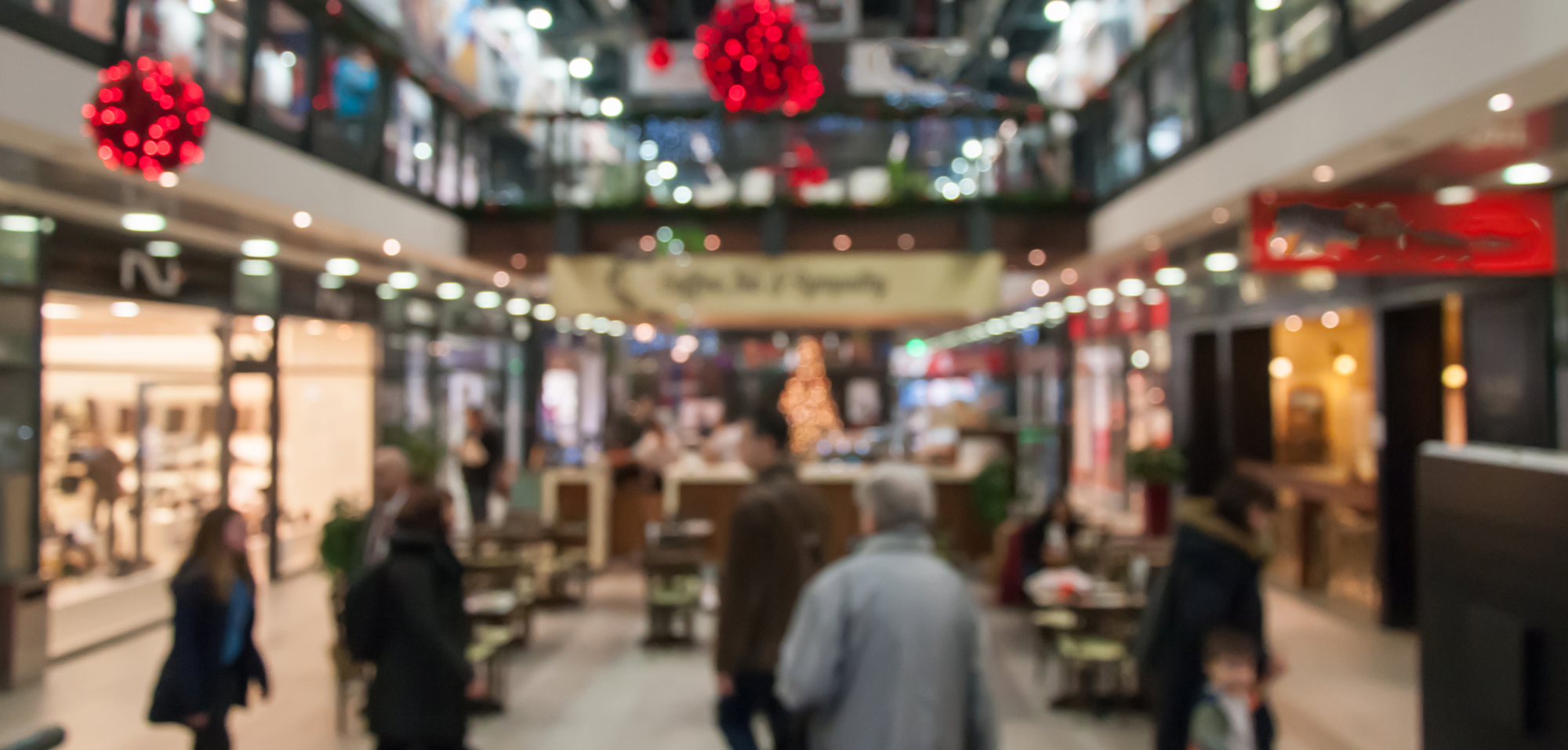 Juldekorerad shoppinggalleria med folk som handlar