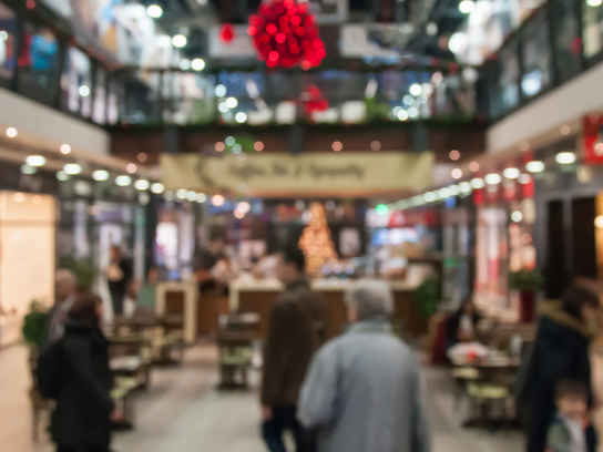 Juldekorerad shoppinggalleria med folk som handlar