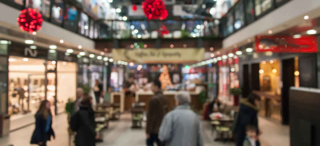 Juldekorerad shoppinggalleria med folk som handlar
