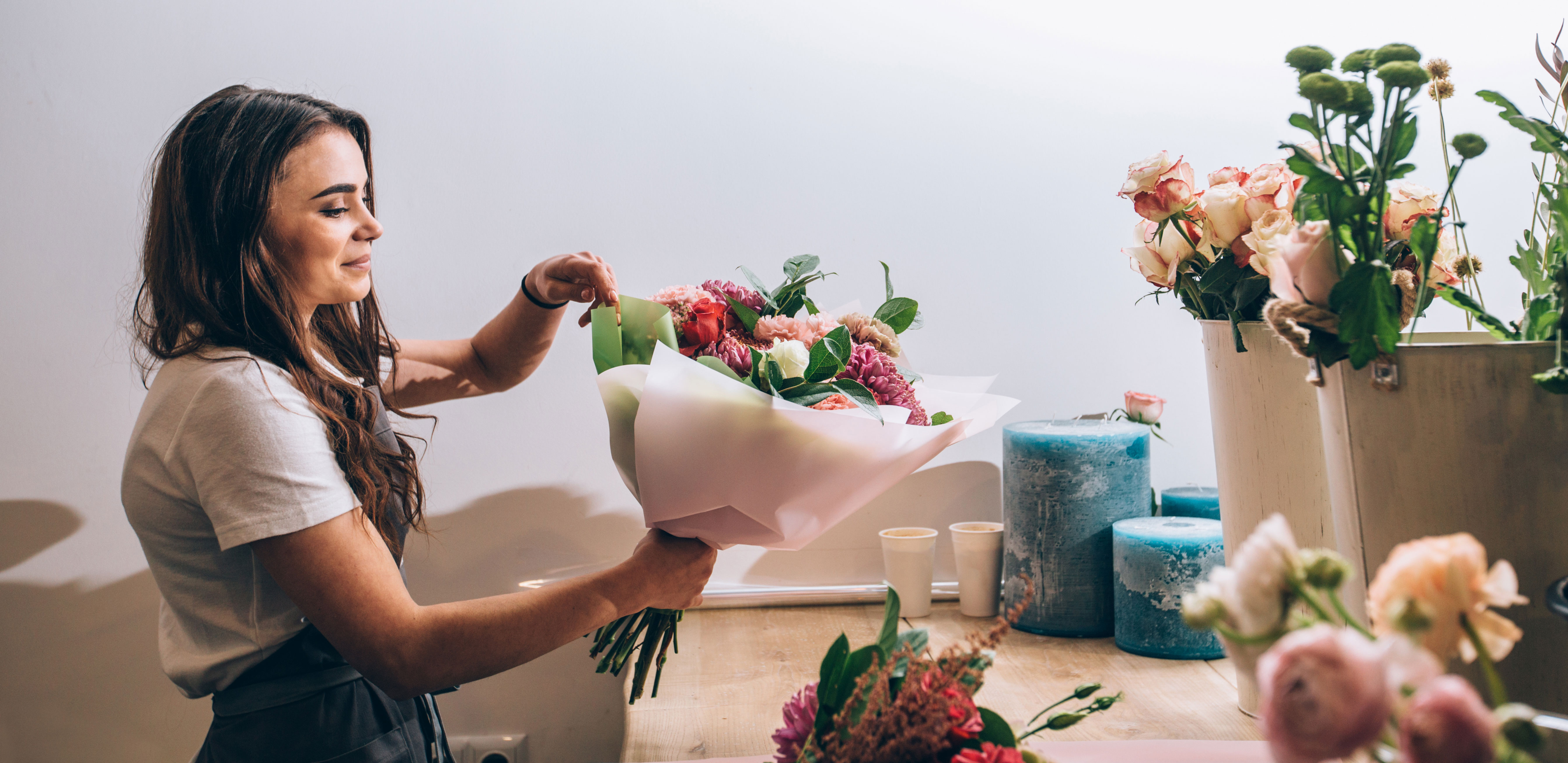 Kvinna i blomsterbutik binder en bukett