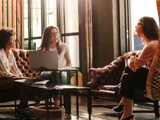 Kvinnor sitter i en soffgrupp och har ett möte