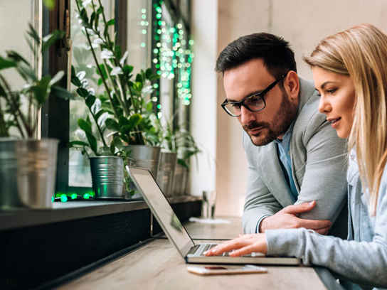 Par med laptop vid bord