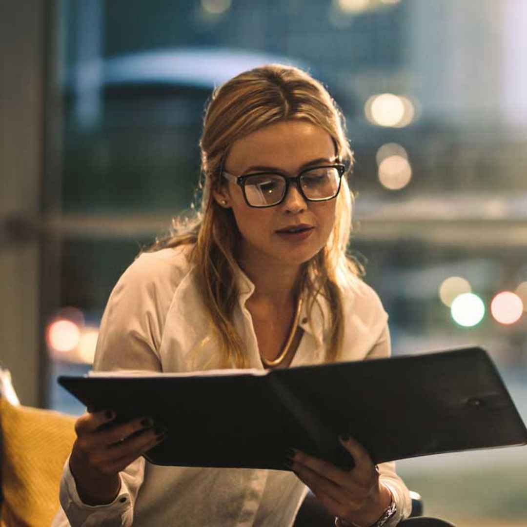 Kvinna med glasögon läser dokument