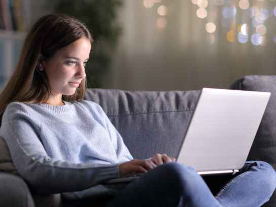 Tjej i soffa med laptop