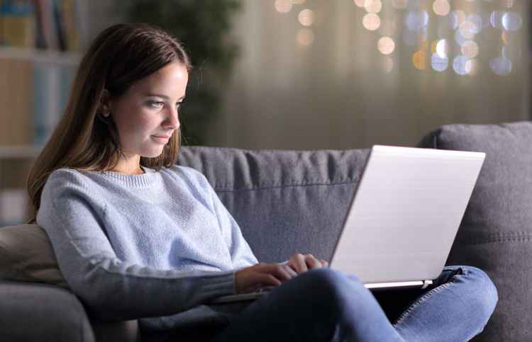 Tjej i soffa med laptop