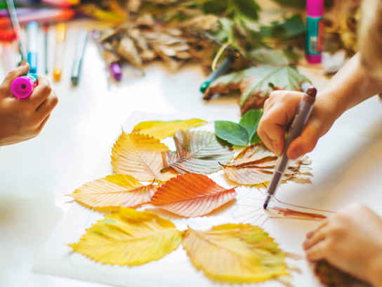 Barn som målar och pysslar med höstlöv