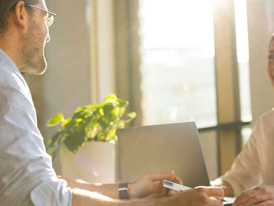 Man och kvinna samtalar vid ett skrivbord