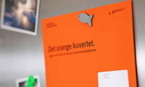 Orange kuvert om pension på kylskåp
