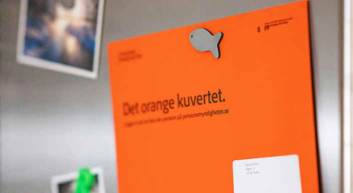 Orange kuvert om pension på kylskåp